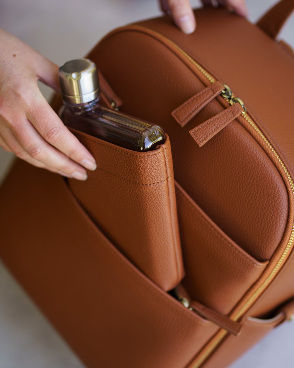 Memobottle waterbottle inserted into matching Mina Camera bag in Tan vegan leather