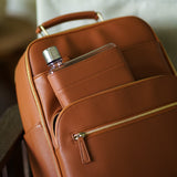 Memobottle water bottle with tan leather sleeve in matching Lyra Camera Backpack