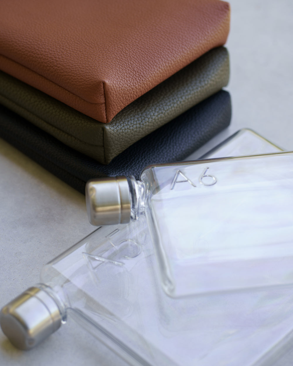 Camera Bag water bottle in two sizes with matching vegan leather sleeves in tan, olive and black