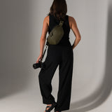 Photographer holding mirrorless camera attached with strap to Versa fanny pack
