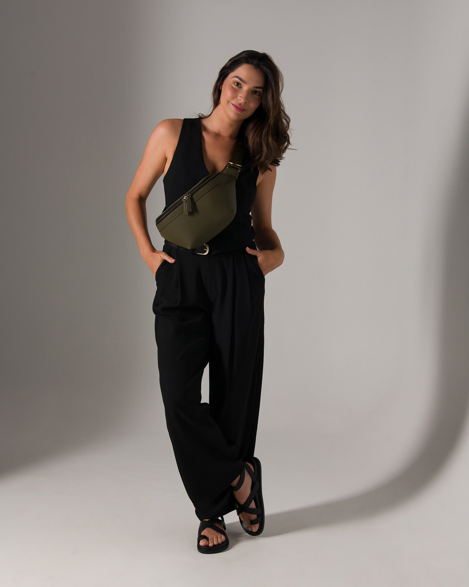Woman photographer wearing Versa camera bag crossbody style wearing stylish travel clothes