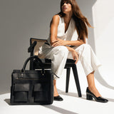 Avana Camera Bag front view in black with stylish model in photo studio