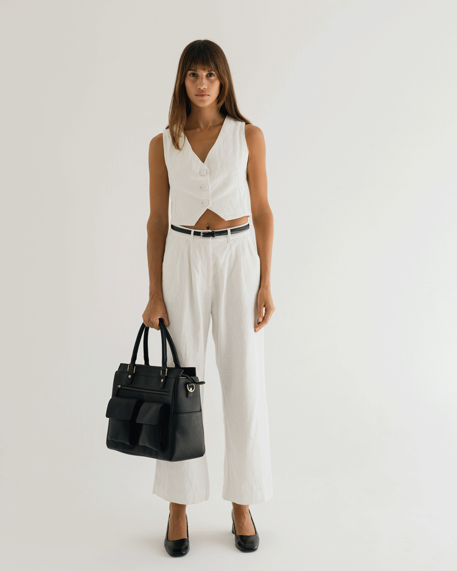 Woman photographer holding Avana Camera Handbag while turning in photography studio