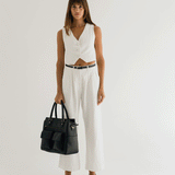 Woman photographer holding Avana Camera Handbag while turning in photography studio