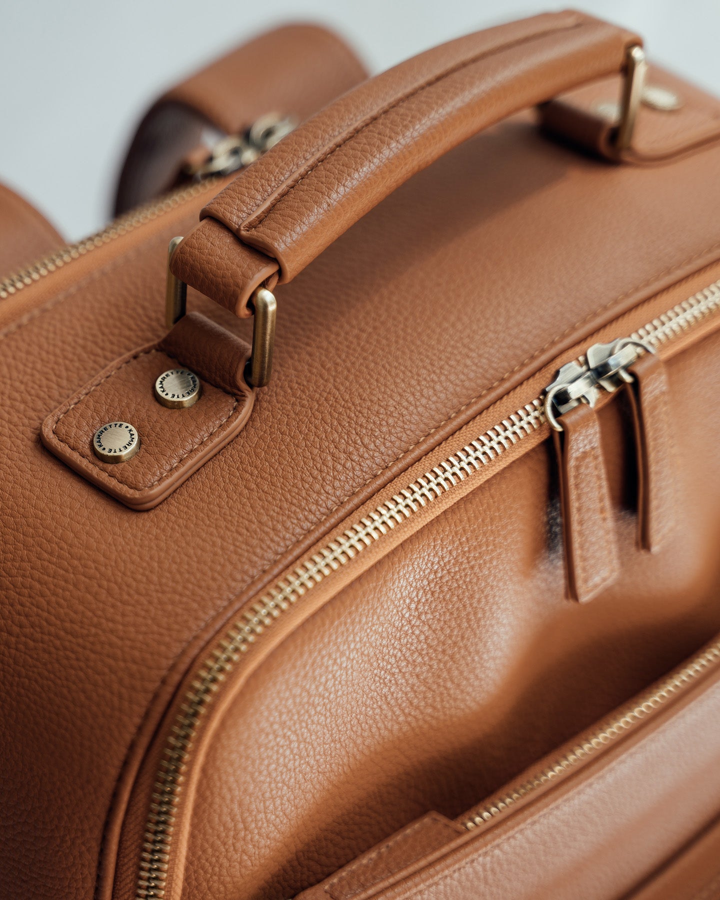 Vegan leather handle and aesthetic brushed brass hardware and zippers