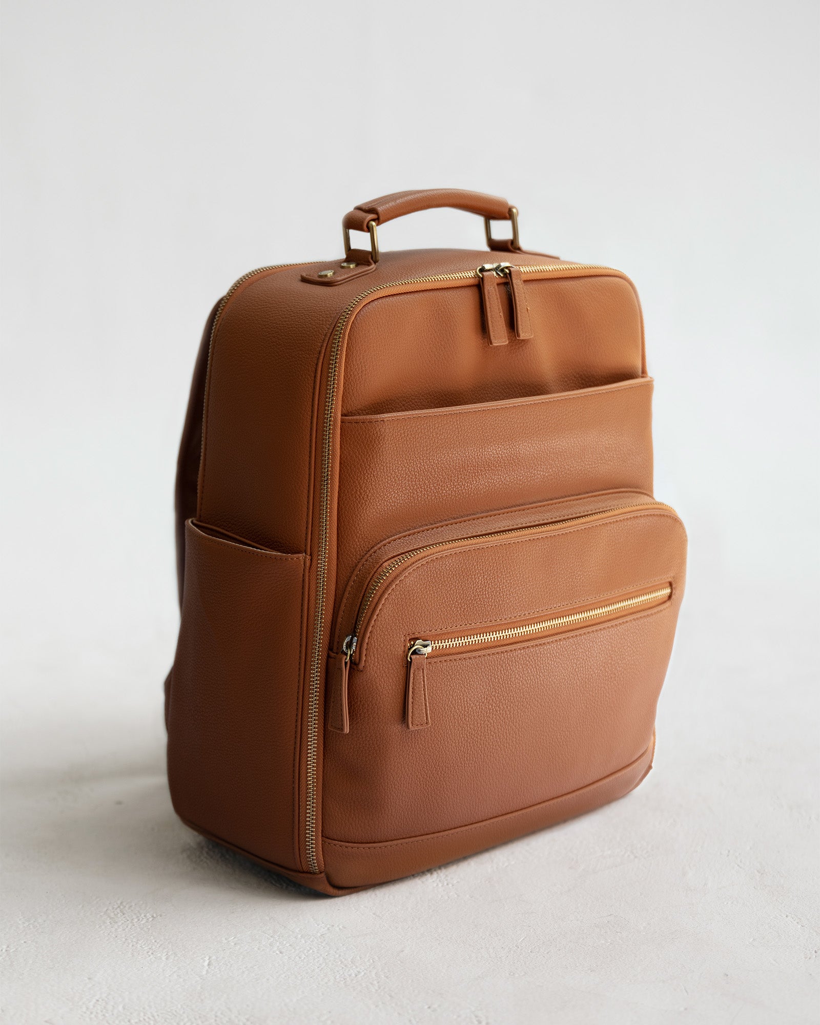Lyra Camera Backpack - front view in tan vegan leather