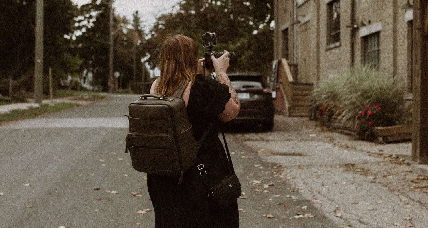 Photographer wearing an olive Lyra camera bag while holding a camera at a photoshoot