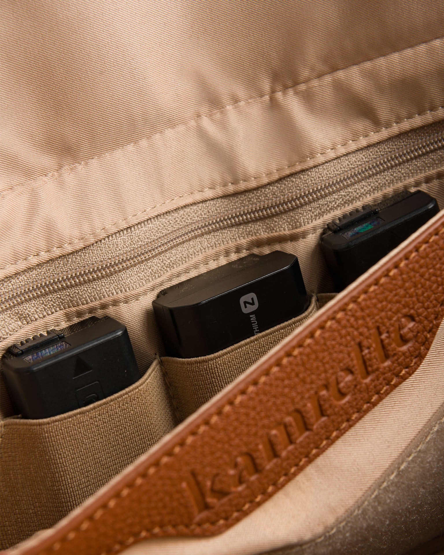 Interior of Versa camera bag featuring secure zip storage and holder for camera batteries