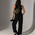 Photographer holding mirrorless camera attached with strap to Versa fanny pack