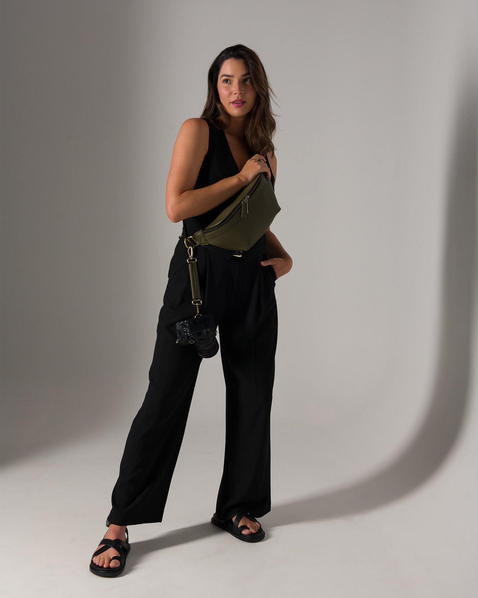 Photographer in studio wearing Versa Fanny Pack with camera strap