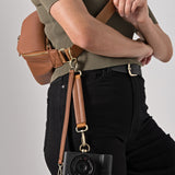 Photographer with Sony mirrorless camera securely clipped to Versa camera strap system