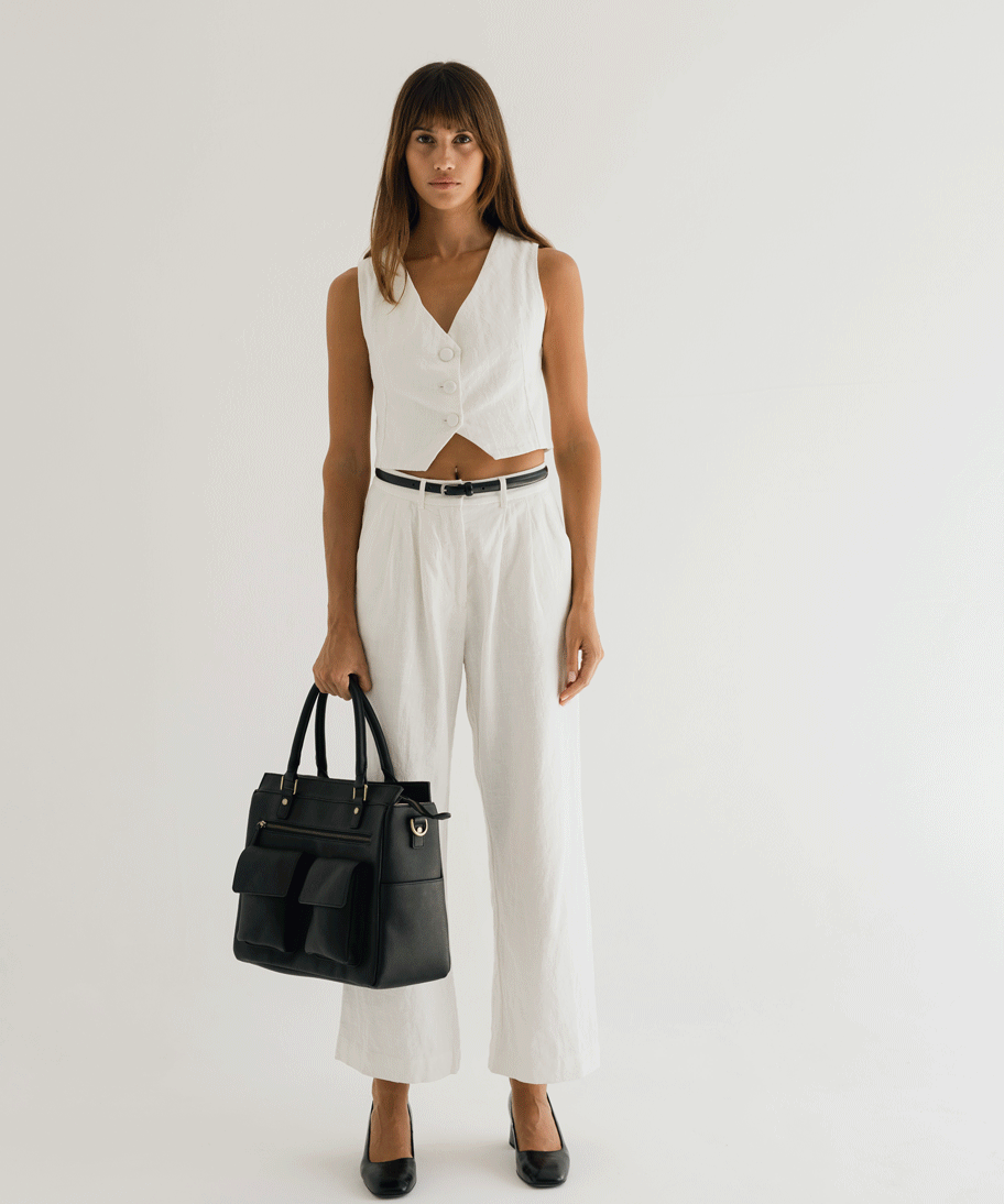 Woman photographer holding Avana Camera Handbag while turning in photography studio 