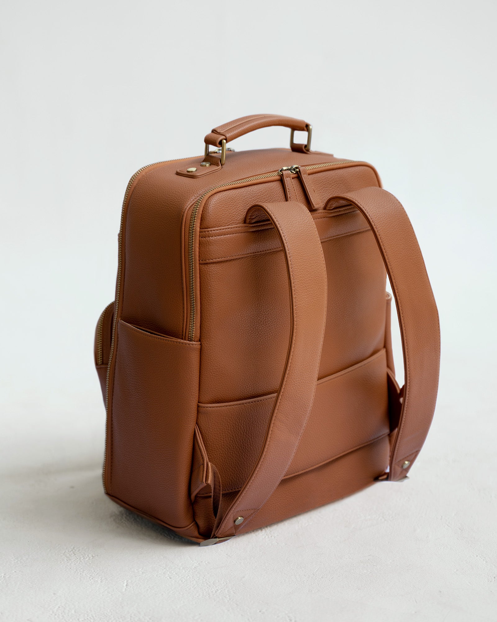 Back view of Lyra camera backpack in Tan with padded straps, laptop compartment and luggage sleeve