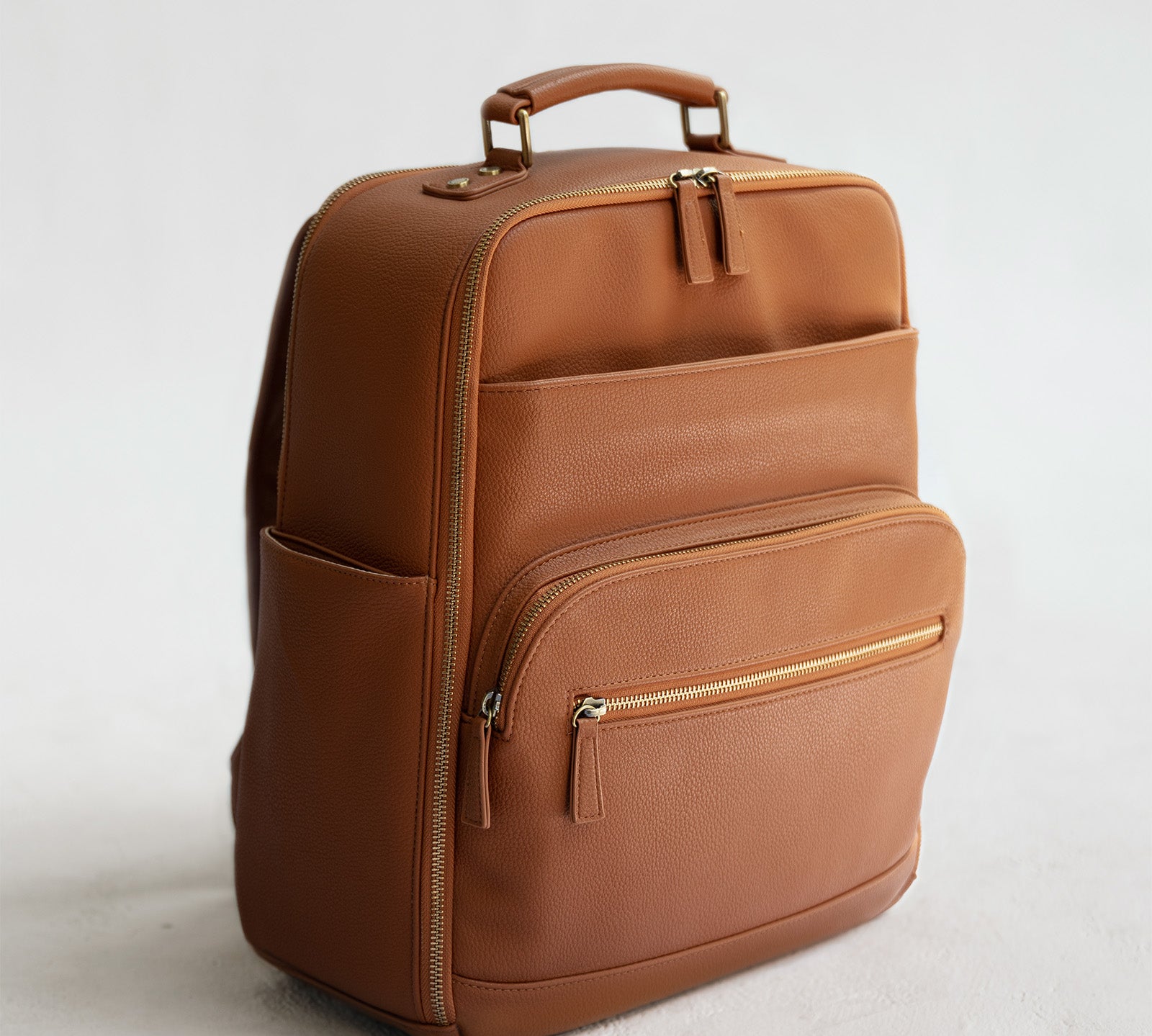Lyra Camera Backpack - front view in tan vegan leather