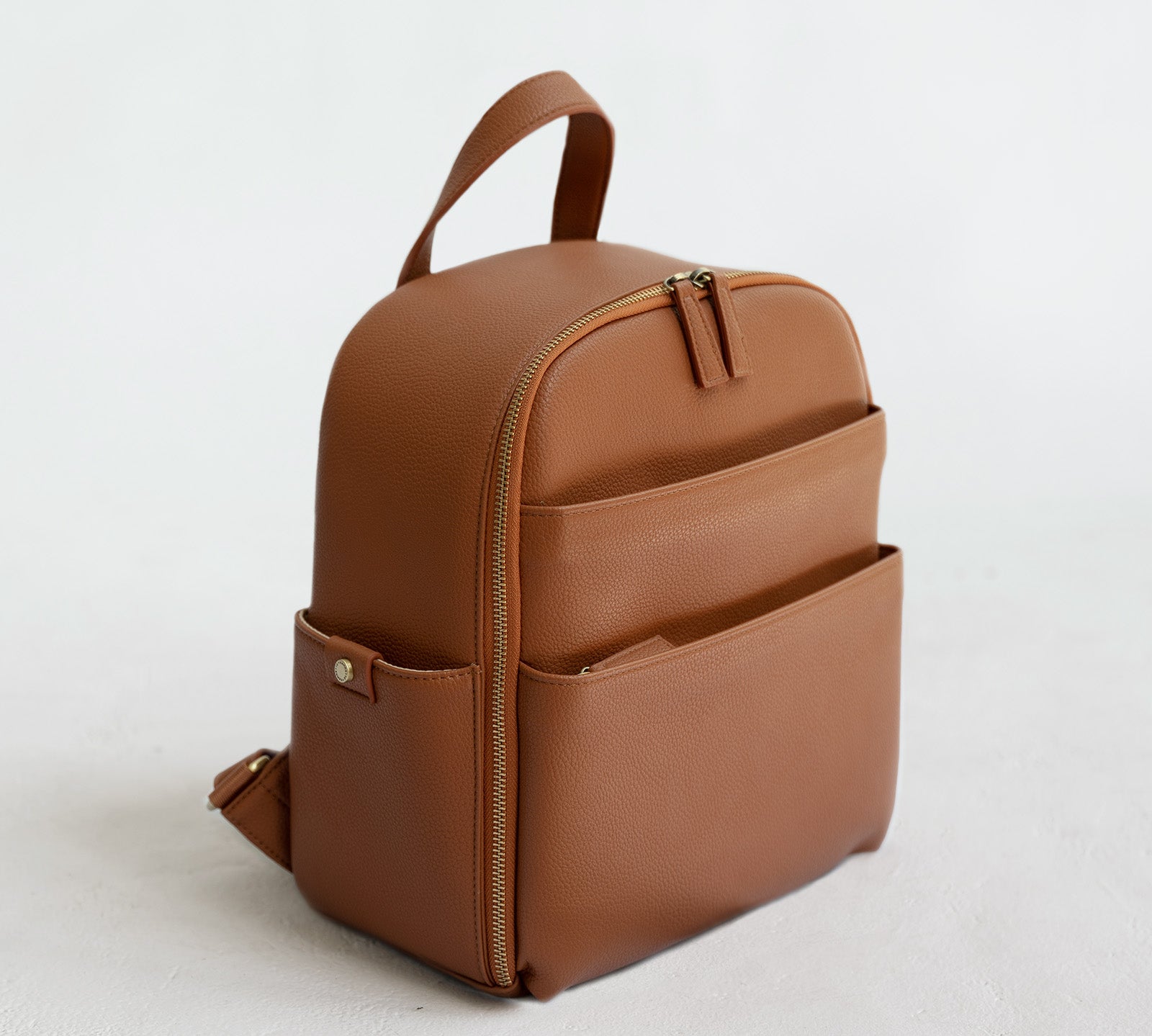 Mina Camera Backpack - front view in tan vegan leather and brushed brass hardware