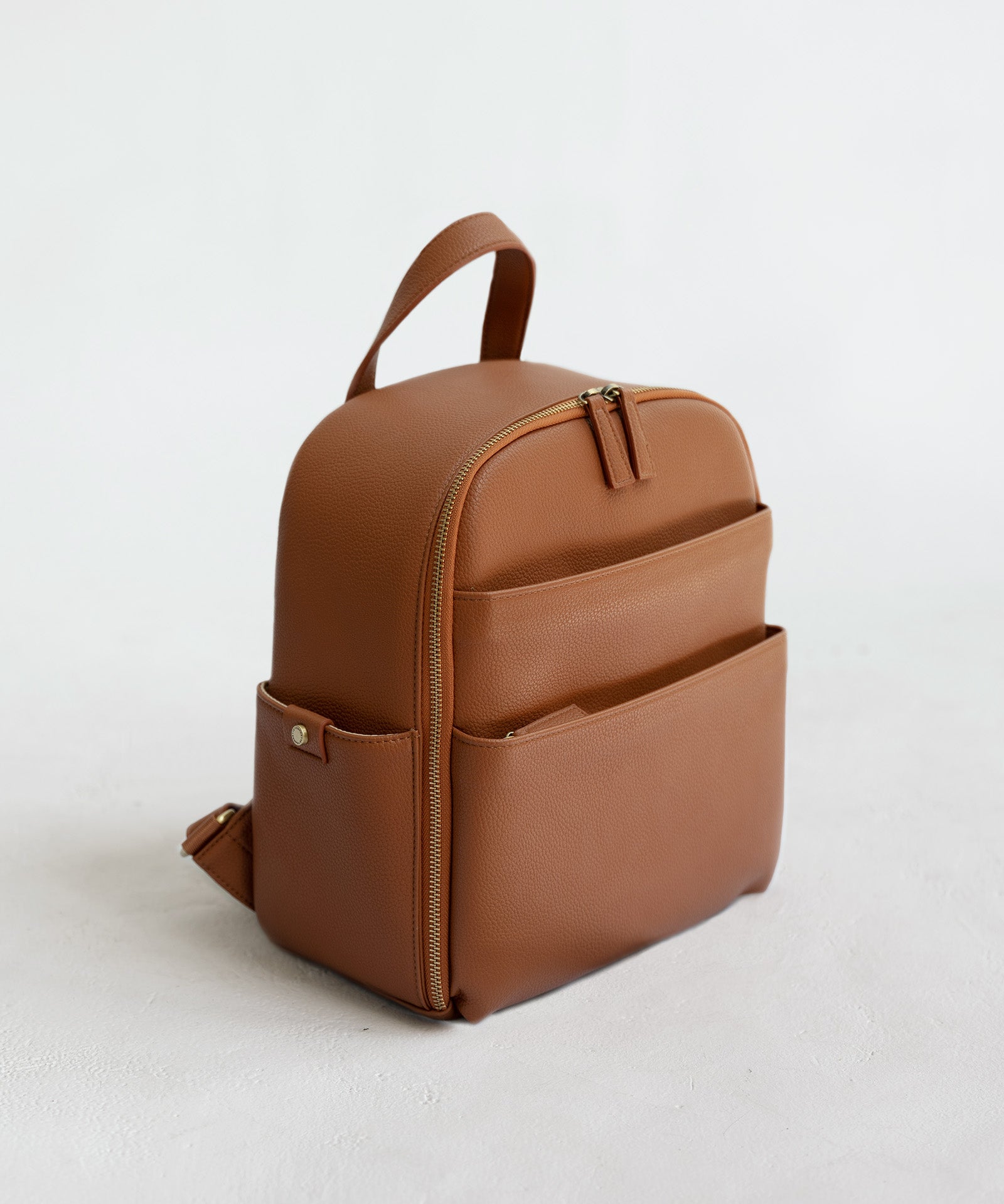 Mina Camera Backpack - front view in tan vegan leather and brushed brass hardware