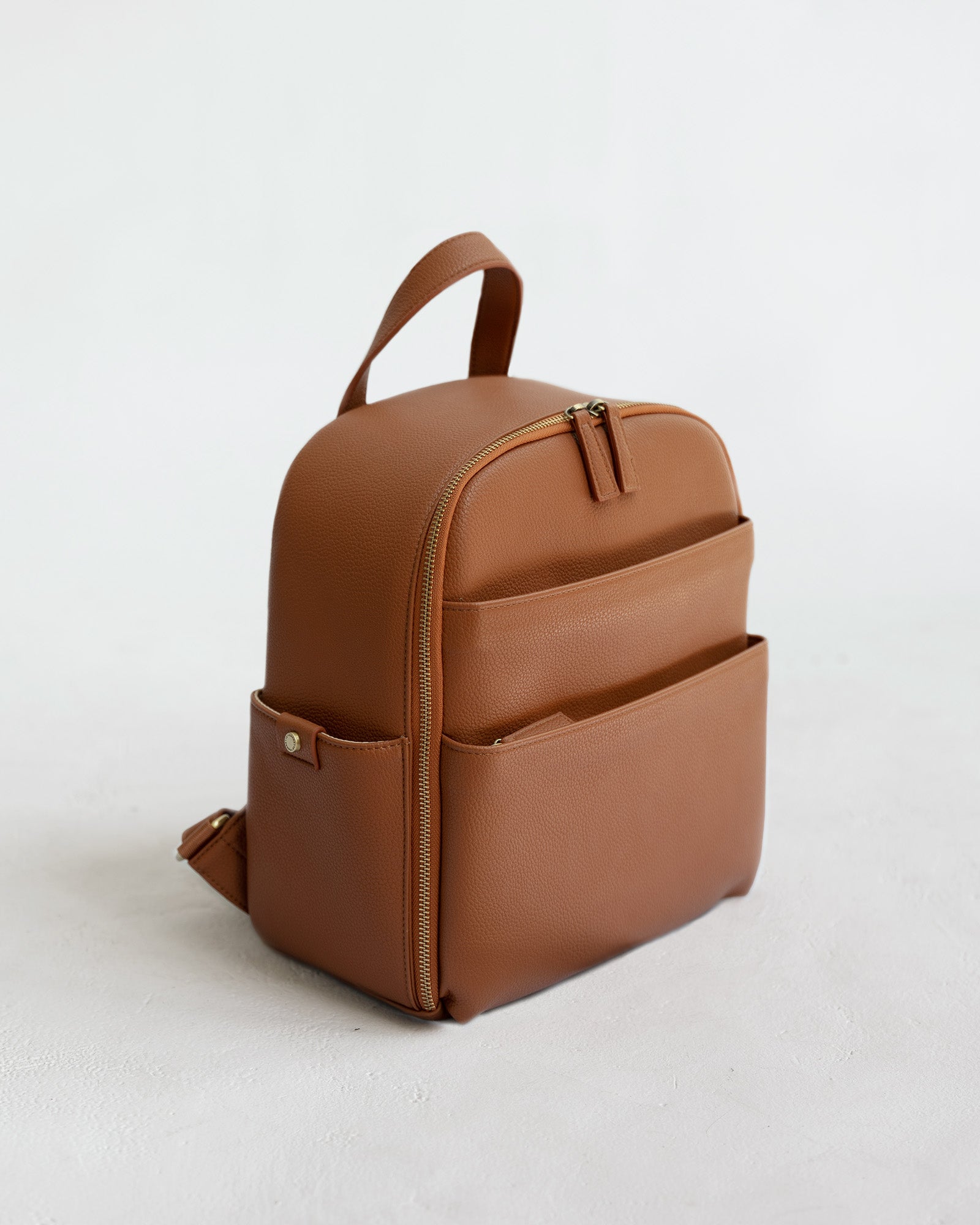 Mina Camera Backpack - front view in tan vegan leather and brushed brass hardware